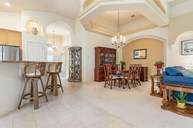 tiled dining room with an inviting chandelier and a high ceiling