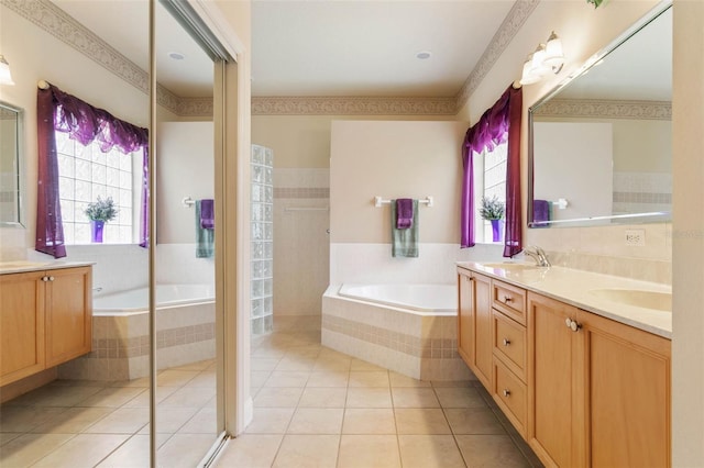 bathroom featuring plus walk in shower, vanity, and tile patterned flooring