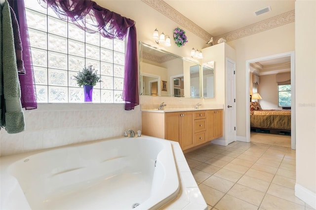 bathroom with tiled tub, vanity, ornamental molding, and tile patterned flooring