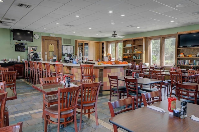 dining area with ceiling fan and a drop ceiling