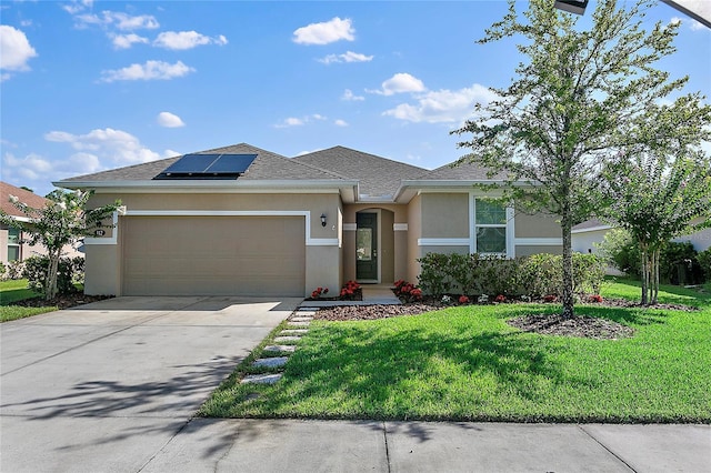 view of front of home featuring an attached garage, solar panels, concrete driveway, stucco siding, and a front yard