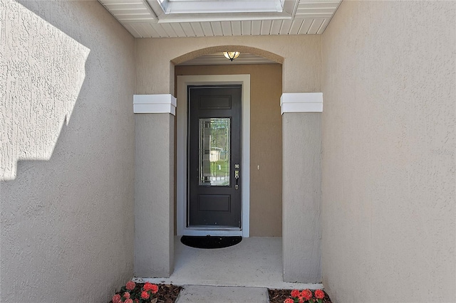 doorway to property featuring stucco siding