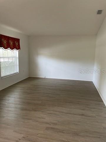 empty room with dark hardwood / wood-style flooring