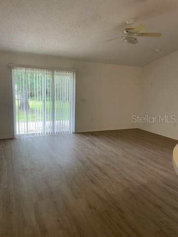 spare room with a ceiling fan, a textured ceiling, and wood finished floors