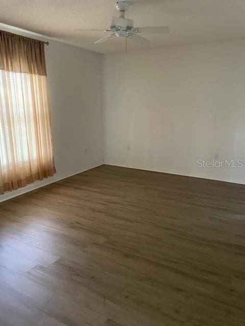 spare room featuring ceiling fan, a textured ceiling, and dark wood-style flooring