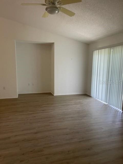 empty room featuring a textured ceiling, ceiling fan, and dark hardwood / wood-style flooring