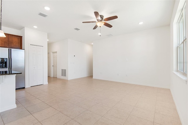 unfurnished living room featuring light tile patterned floors and ceiling fan