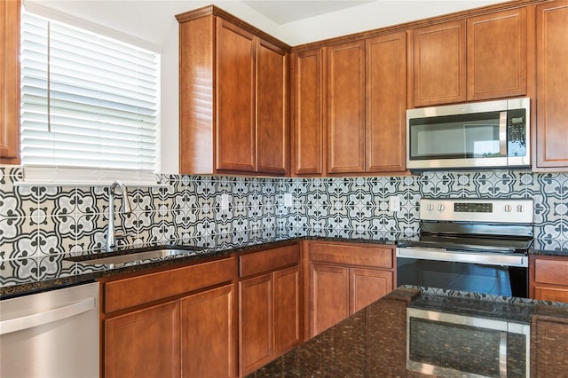 kitchen featuring dark stone countertops, sink, and appliances with stainless steel finishes