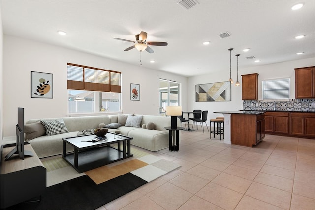 living room featuring ceiling fan, light tile patterned flooring, and sink