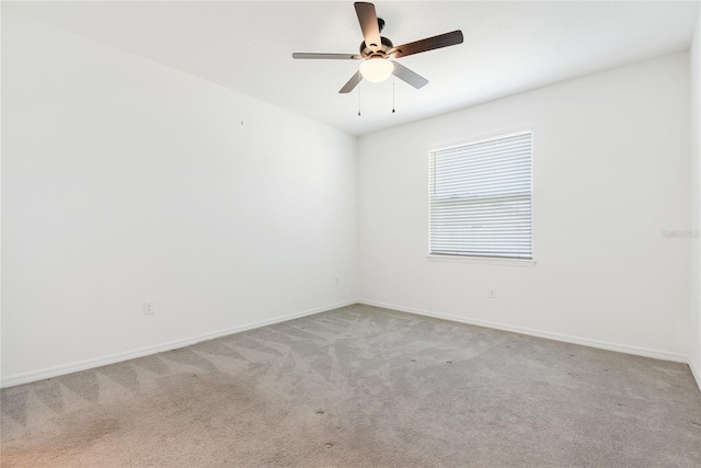 spare room with ceiling fan and light carpet