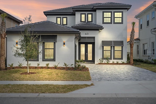 view of front facade with a lawn and french doors