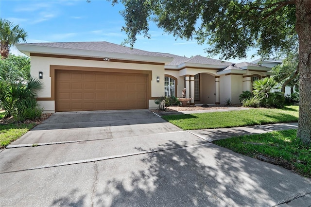 view of front of house with a front lawn, concrete driveway, an attached garage, and stucco siding