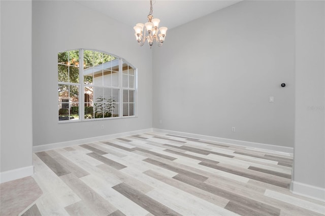 empty room featuring light hardwood / wood-style floors and an inviting chandelier