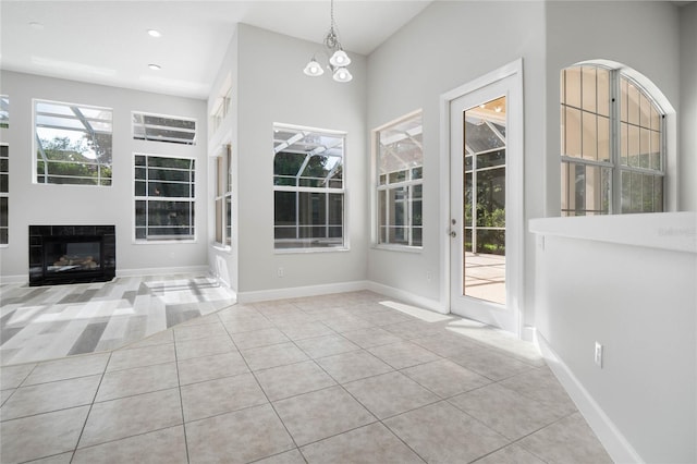 interior space with light tile patterned floors and an inviting chandelier