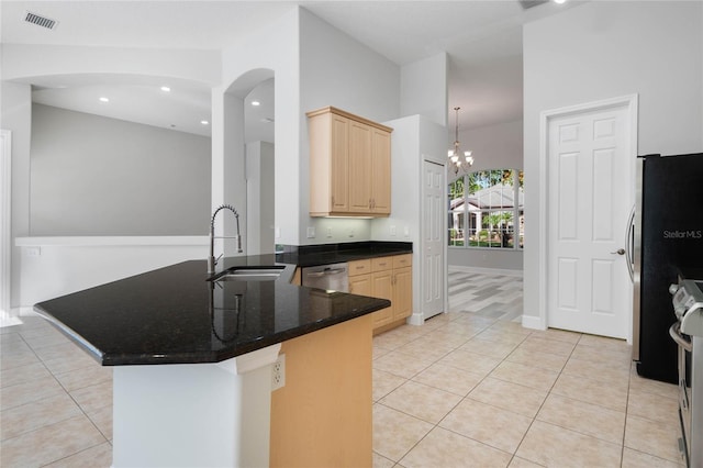 kitchen with kitchen peninsula, light brown cabinets, stainless steel appliances, and sink