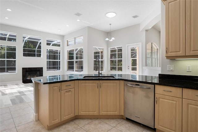 kitchen with stainless steel dishwasher, light tile patterned flooring, sink, and light brown cabinets