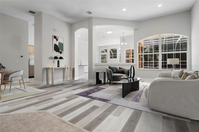 living area featuring baseboards, visible vents, wood finished floors, and recessed lighting