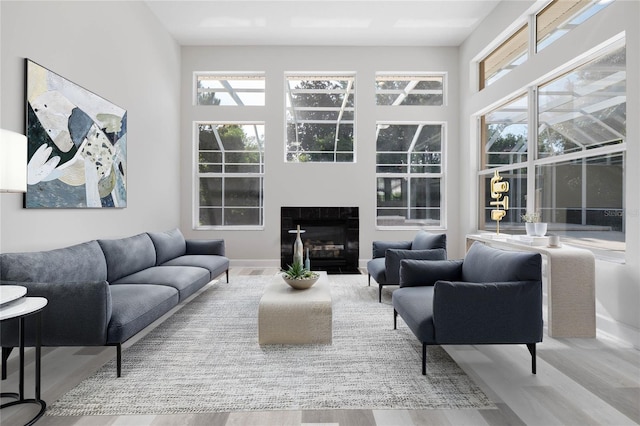 living room with baseboards, a tiled fireplace, and wood finished floors