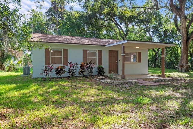 ranch-style house with central AC, a front yard, and a carport