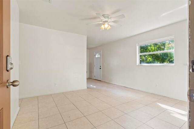 unfurnished room with ceiling fan and light tile patterned flooring