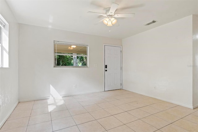 tiled empty room featuring ceiling fan