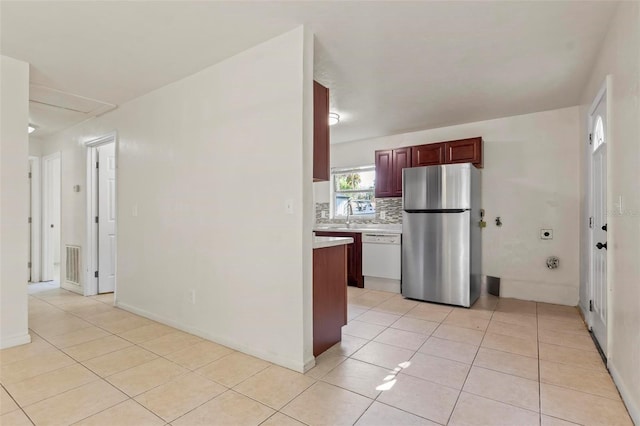 kitchen with dishwasher, sink, decorative backsplash, stainless steel fridge, and light tile patterned flooring