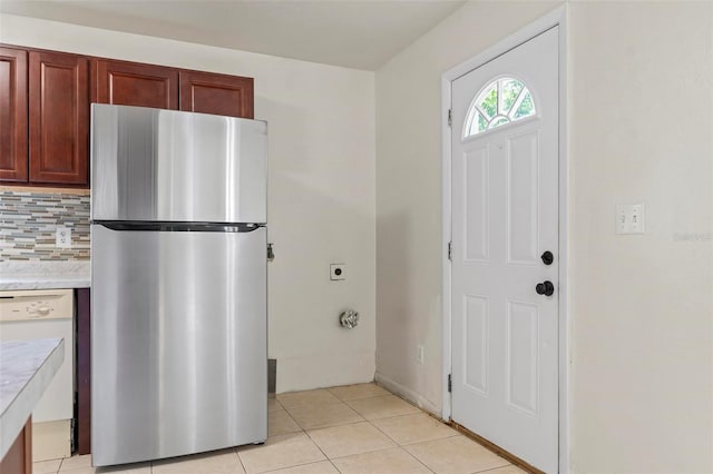 kitchen featuring tasteful backsplash, stainless steel fridge, dishwasher, and light tile patterned floors