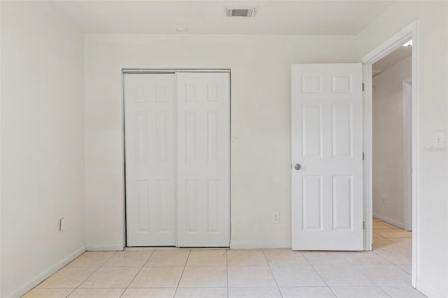 unfurnished bedroom with a closet and light tile patterned floors