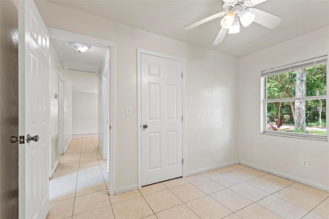 unfurnished bedroom with ceiling fan, a closet, and light tile patterned floors