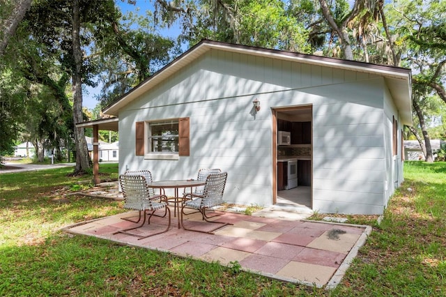 rear view of property with a patio and a lawn