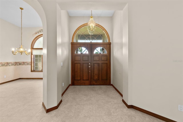 entryway with light tile patterned flooring and a notable chandelier