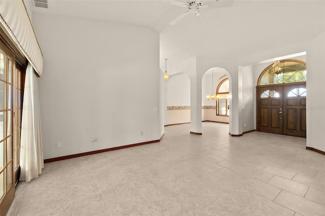 foyer entrance featuring vaulted ceiling, ceiling fan with notable chandelier, and light tile patterned floors