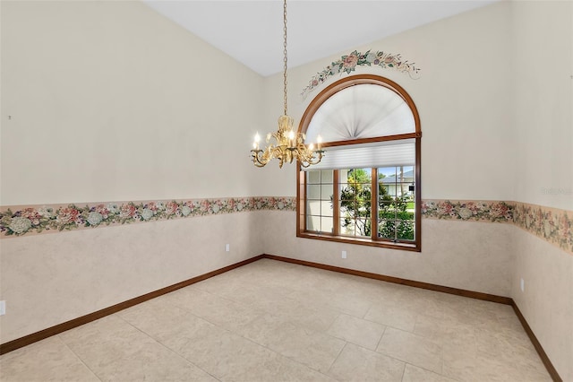 empty room featuring tile patterned flooring and a chandelier