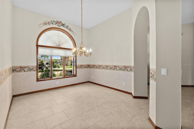 spare room with light tile patterned floors and a chandelier