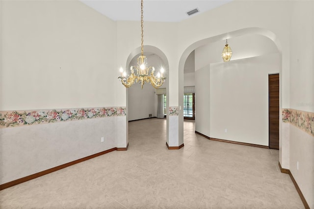 empty room with an inviting chandelier and a towering ceiling