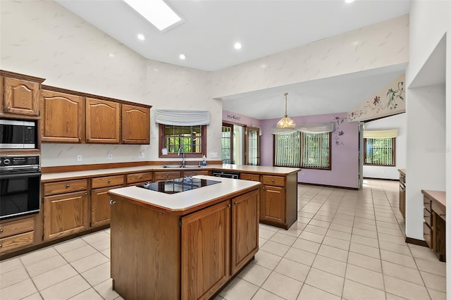 kitchen featuring pendant lighting, black appliances, a center island, and light tile patterned flooring