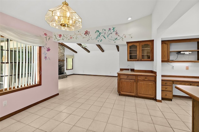 kitchen with hanging light fixtures, a large fireplace, sink, and light tile patterned flooring