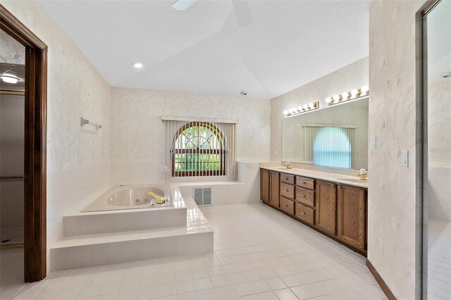 bathroom featuring vanity, lofted ceiling, tiled bath, and ceiling fan