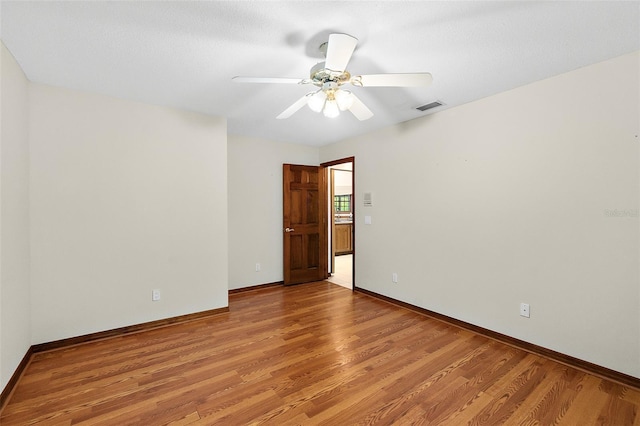 empty room with ceiling fan and light wood-type flooring