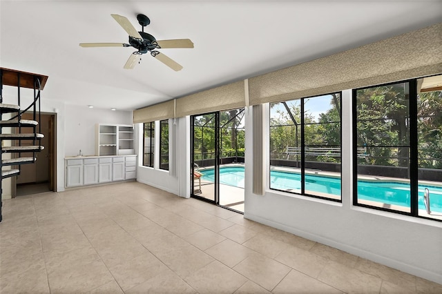 unfurnished living room featuring lofted ceiling, ceiling fan, and light tile patterned flooring