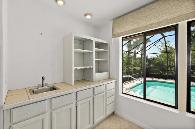 interior space with white cabinetry and sink