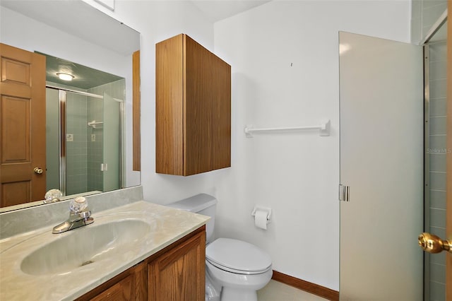 bathroom with vanity, a shower with shower door, and toilet