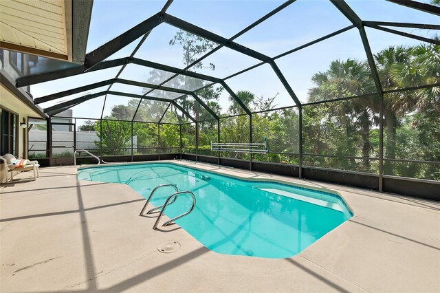 view of pool with a patio and glass enclosure