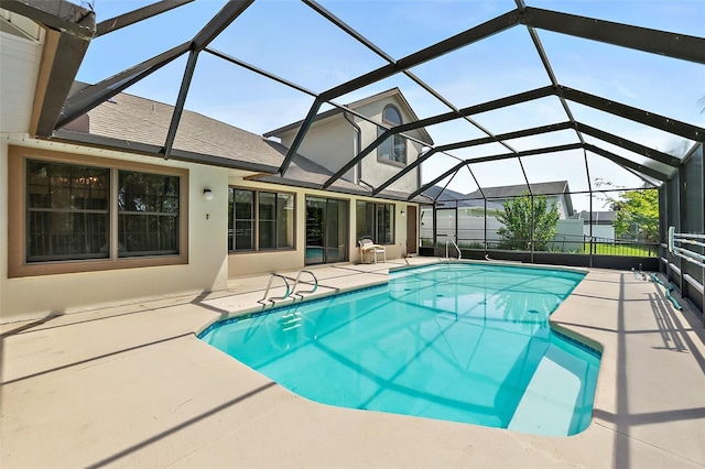 view of pool with a patio area and glass enclosure