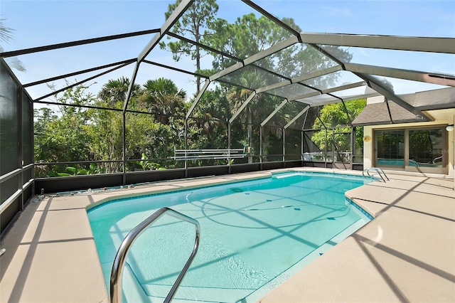 view of pool featuring glass enclosure and a patio area