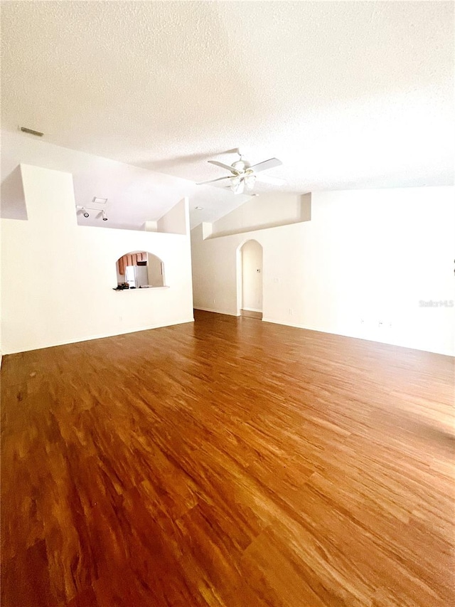 spare room featuring vaulted ceiling, a textured ceiling, ceiling fan, and hardwood / wood-style floors