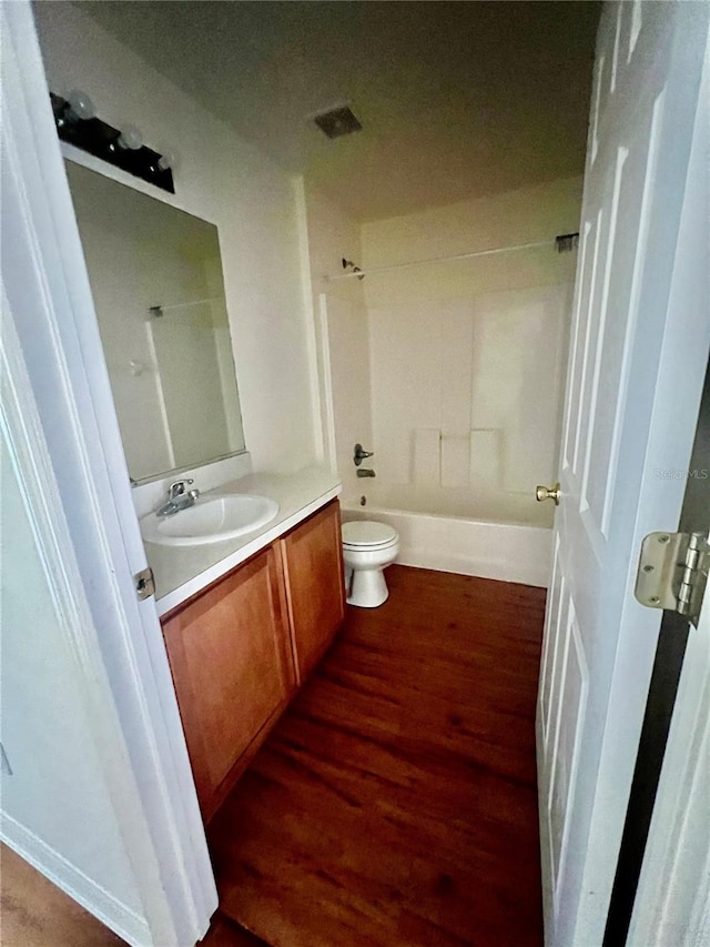 full bathroom featuring hardwood / wood-style floors, toilet, shower / washtub combination, and vanity