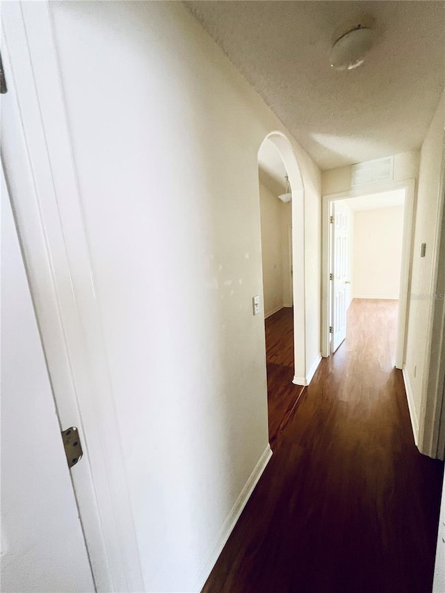 corridor featuring a textured ceiling and hardwood / wood-style flooring