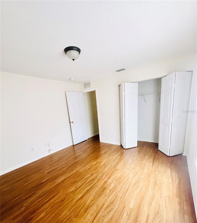 unfurnished bedroom featuring light hardwood / wood-style floors and a closet