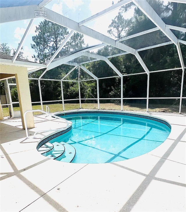 view of pool with a patio area and a lanai